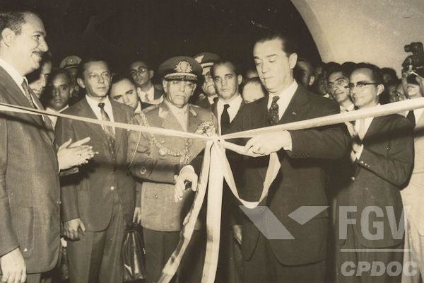 Juscelino Kubitschek cortando uma fita em um evento de inauguração